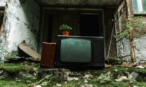 retro tv near travel bag on green stairs with mold